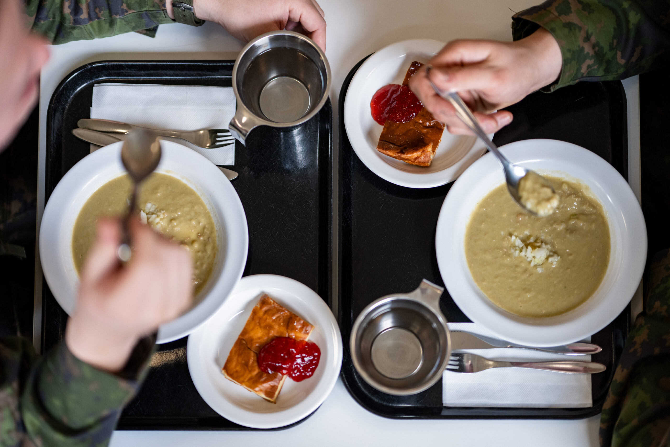 Varusmiehet syömässä hernekeittoa ja pannukakkua